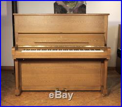 A 1985, Steinway Model K upright piano with a polished, oak case