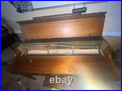Brown wood baldwin piano with wheels and bench rarely used