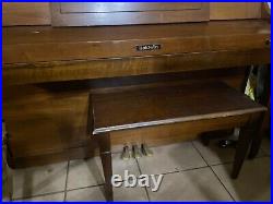 Brown wood baldwin piano with wheels and bench rarely used